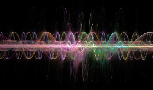 Digitally generated waves in a spectrum of vivid colors set against a black backdrop