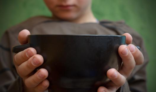 Hands of a child holding an empty bowl
