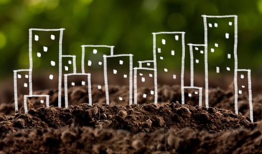 Conceptual image showing chalk drawings of cityscape growing out of the ground