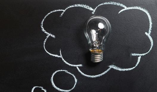 Image of a lightbulb framed by a chalkboard drawing of a thought balloon.